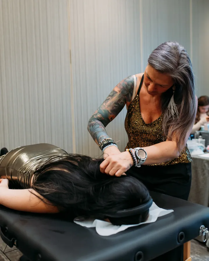 Jen's hands resting lightly at the base of a client's head